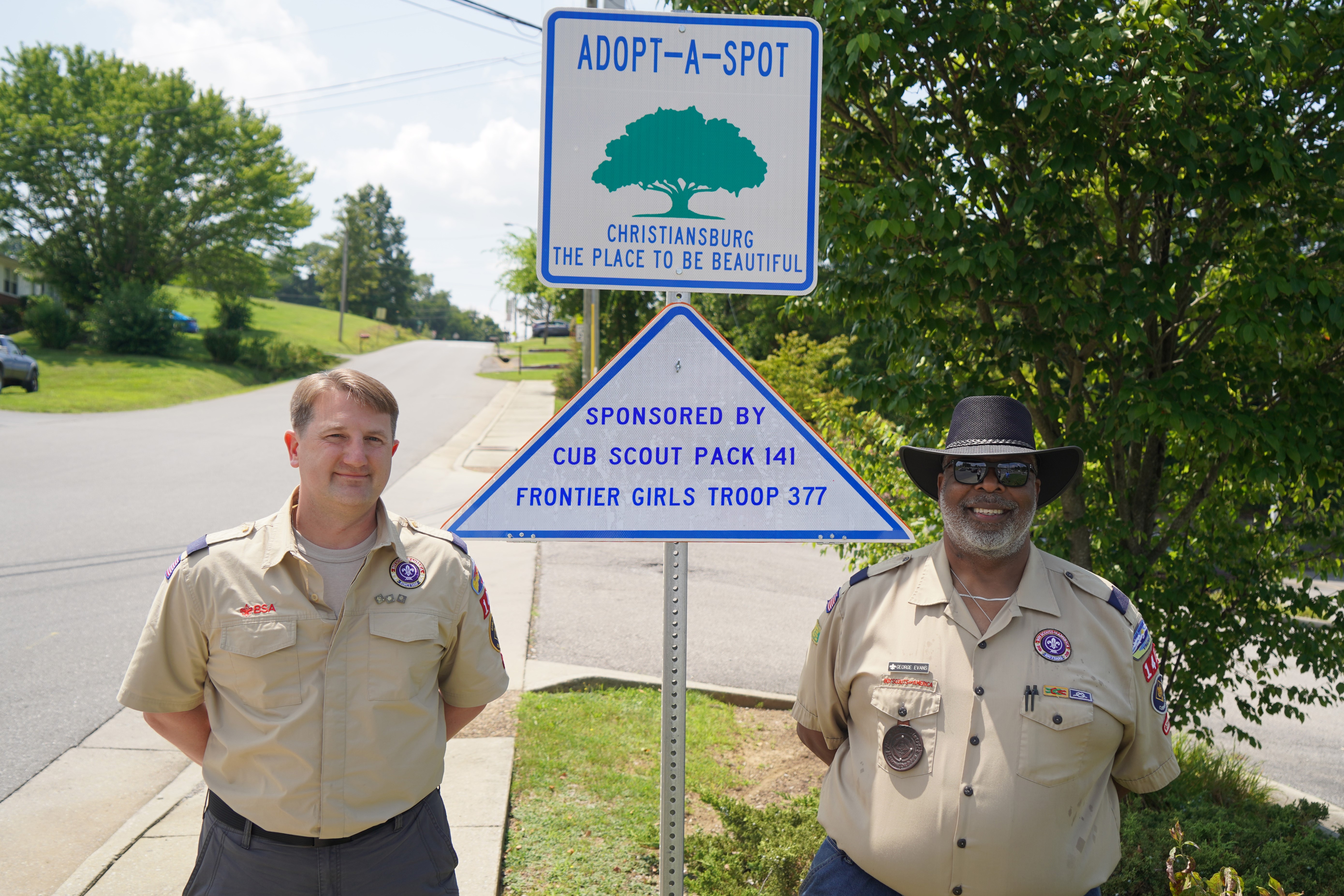 Scout leaders in front of sign